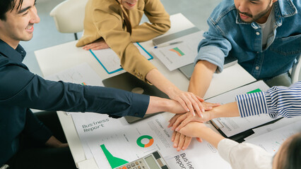 Collaborative team meeting with hands joined over business reports, showcasing teamwork and strategy. Leader Teamwork stratup