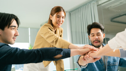 Obraz premium Team collaboration in modern office setting, hands joining together in unity and support. atmosphere is positive and focused on teamwork. Leader Teamwork stratup