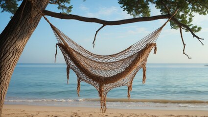 Rustic net hammock swaying from a tree on a serene beach with calm ocean waters under a clear sky promoting relaxation and tranquility.