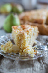 Homemade pear pie on a white table with pears in the background