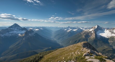 Obraz premium Expansive Mountain Landscape with Lush Green Slopes and Majestic Snow-Capped Peaks Under a Clear Blue Sky