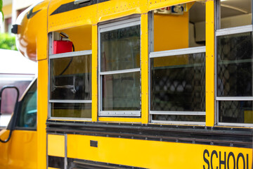 Detail of an American school bus with windows and bright yellow exterior........