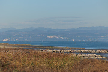 ambiente naturale costiero del Mare Adriatico con bassa marea, vicino al Golfo di Trieste, colorato di arancione dalla luce del sole al tramonto, in inverno