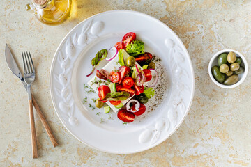 Mediterranean cuisine. Greek salad of tomatoes, cucumbers, feta cheese and herbs.