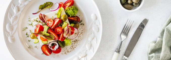 Fresh Greek salad in a white plate on a wooden background. Mediterranean cuisine