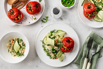 Stuffed tomatoes with couscous salad, cucumber and green peas. Mediterranean food.