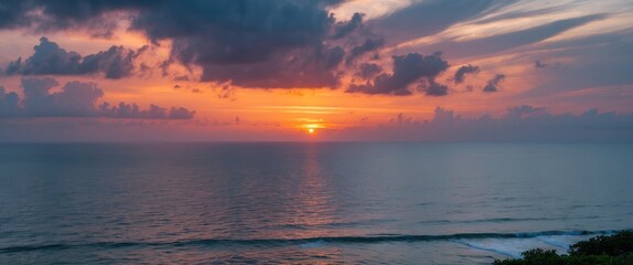 Naklejka premium Serene Coastal Sunset with Dramatic Cloud Cover Over the Ocean and Inter Coastal Waterway