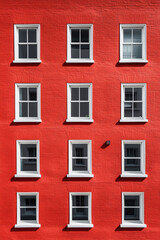 Fototapeta premium Red Building Facade with White Framed Windows