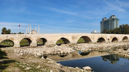 Fototapeta premium The historic arched stone bridge called Taşköprü, one of the symbols of Adana, located on the Seyhan River, was built by the Roman architect Auxentus in 384 AD.