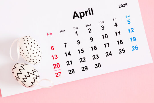 Close-up of a desk paper calendar sheet for April 2025 with Easter date highlighted and Easter decor