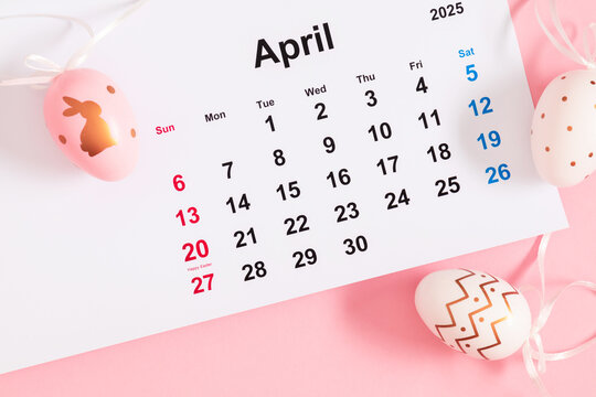 Close-up of a desk paper calendar sheet for April 2025 with Easter date highlighted and Easter decor