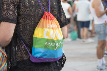 person taking on his back a lgbt pride and reusable bag in the city. rainbow. Horizontal
