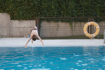 boy jumping and diving headfirst into the pool, swimming, horizontal, copy space, summer