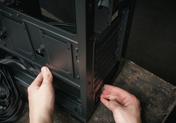 A computer technician installs a computer power supply. Assembling PC