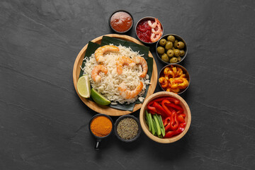 Pieces of banana leaf with rice and shrimps among other food, spices and sauce on grey textured table, flat lay