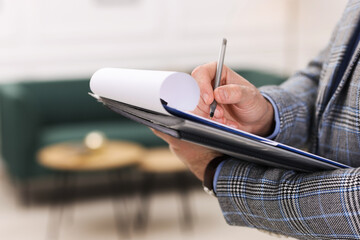 Real estate appraisal. Inspector with clipboard conducting property valuation indoors, closeup....