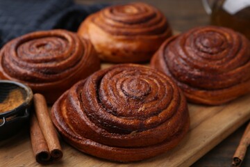 Delicious cinnamon rolls on wooden table, closeup
