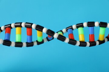 DNA structure model on light blue background, closeup