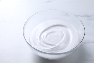 Bowl of whipped cream on white marble table