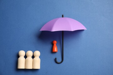 Human figures under umbrella on blue background, top view. Insurance concept