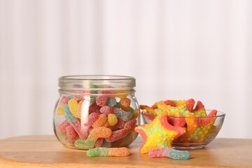Tasty gummy candies on wooden table, closeup
