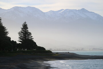 Snow-capped mountain in New Zealand rising above a misty valley. A breathtaking natural scene capturing the beauty of high-altitude landscapes.
