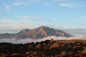 Stunning sunrise over a rugged mountain range in New Zealand, with mist rolling through the valleys. A breathtaking scene perfect for adventure, travel, and nature lovers.