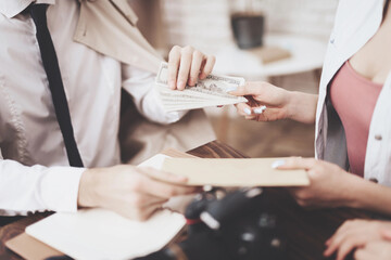 Private detective agency. Man is giving photos and woman is giving money.