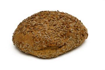 Freshly baked whole grain bread roll with sesame seeds resting on a clean surface