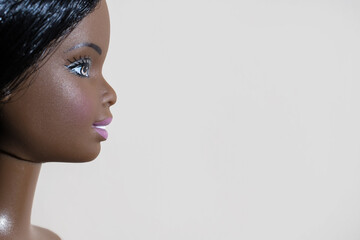 Obraz premium A close-up profile of a Black doll's head, emphasizing shape, texture, and contrast. Place for text.