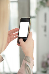 Woman's hand holding a smartphone with a blank screen