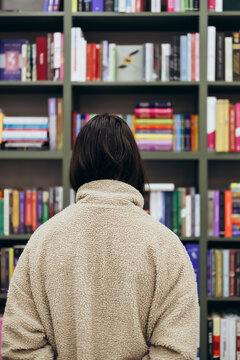 Young girl browsing books in a library setting