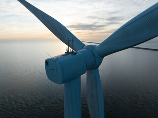 Wind turbine on water, close up view, renewable energy. Aerial drone view.