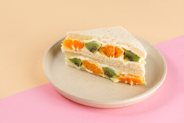 Half sandwiches bread stuffed with mascarpone cream cheese, kiwi and orange. Homemade Korean dessert.