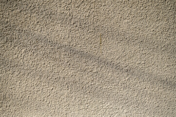 Textured wall illuminated by soft sunlight, showcasing intricate patterns and subtle shadows