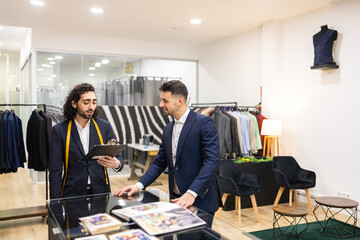 Tailor Discusses Suit Details with Client in Suit Store