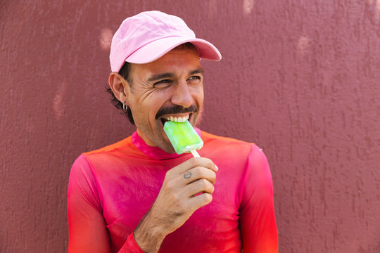 Young man enjoying a popsicle in vibrant pink in Quito, Ecuador