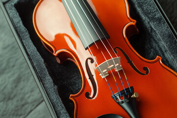 Fototapeta premium Close-up view of a beautifully crafted violin resting in its case alongside the bow