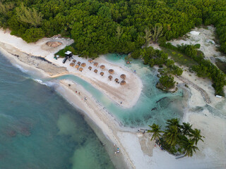 Beach with lifeguards tower and natural umbrellas, drone photo, sunrise