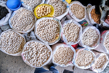 Bags with various types of traditional dried salted cheese, known as kurut in Kyrgyz, kurt in Kazakh, and kurtob in Uzbek, at a market in Central Asia.