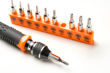 Set of torx and torx security magnetic precision screwdriver bits, and black and orange handle on...