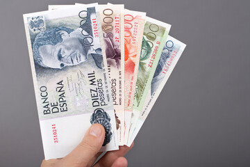 Spanish money in the hand on a gray background