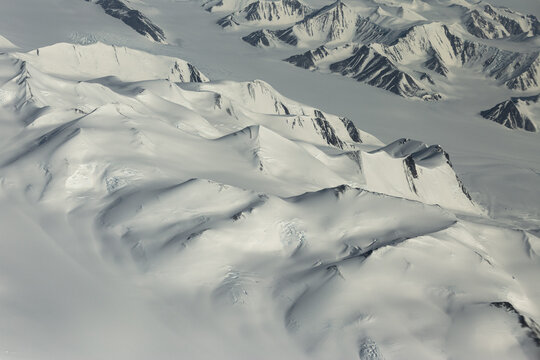 Aerial view of white mountain range in Antarctica.