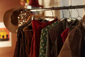 Various patterned and colorful dresses hanging on a clothing rack in a vintage shop. Background...