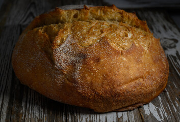 Freshly baked artisan bread resting on rustic wooden table after a warm oven finish