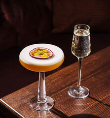 Elegant cocktail and champagne served on wooden table at bar