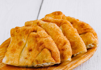 Delicious chebureki pastries resting on wooden plate