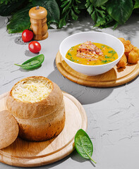 Savory soup served in bread with golden croquettes and fresh garnish