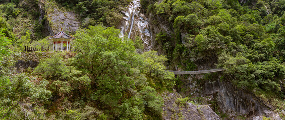 Scenic waterfall lush greenery and traditional pavilion along cliffside trail in Taroko National Park Taiwan