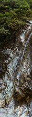 Majestic Cascading Waterfall Flowing Down Rugged Rock Face Amidst Lush Greenery In Taroko National Park